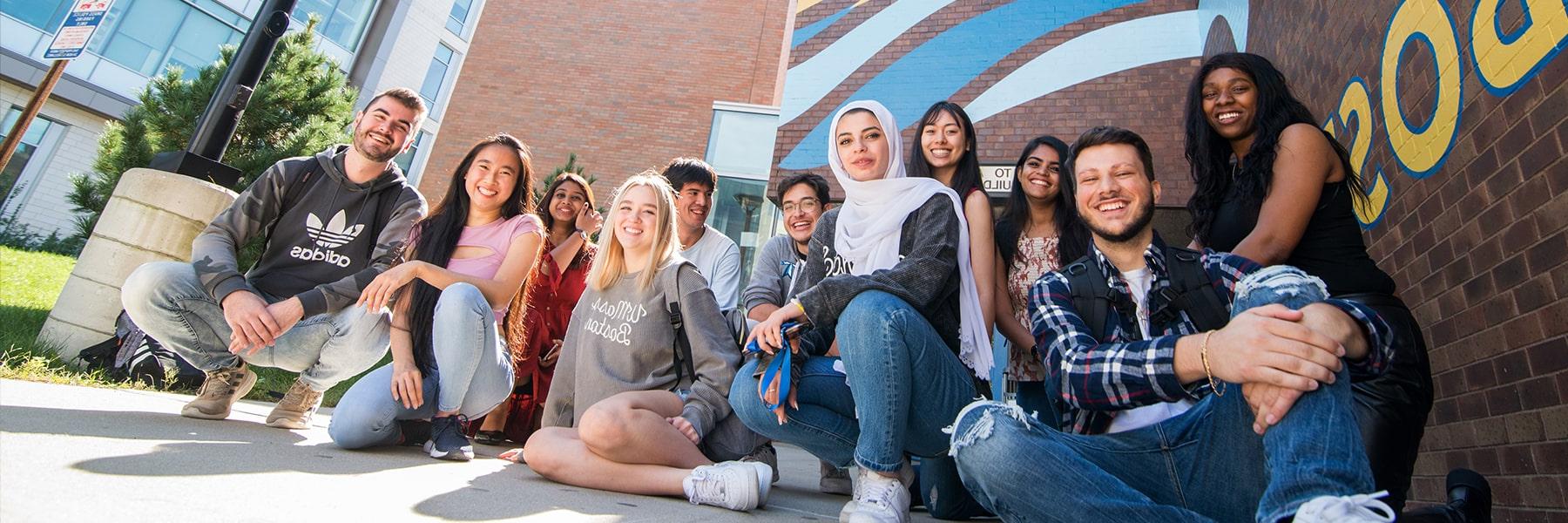 Large group of students pose in front of the Service and Supply building.